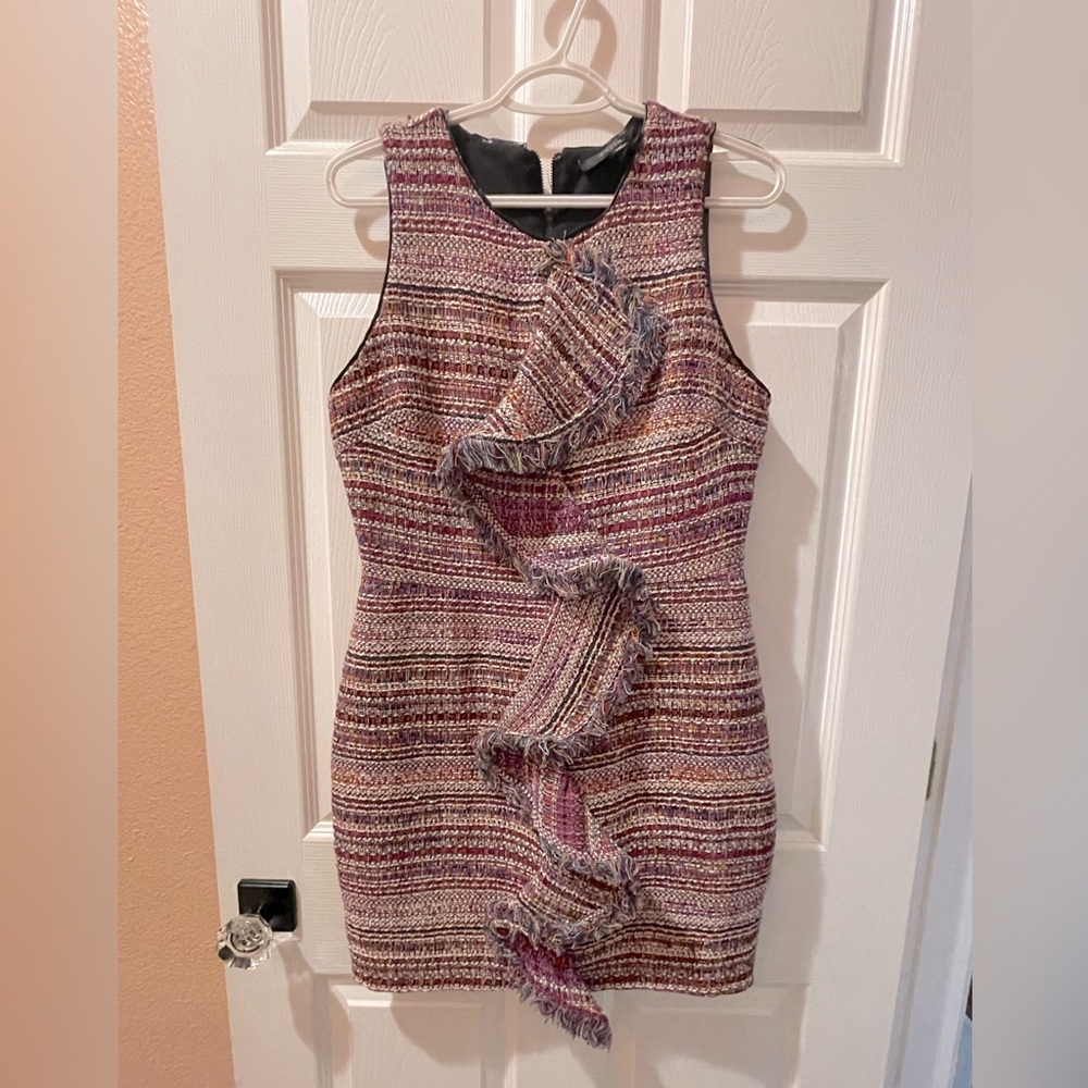 Textured tweed dress with fringe ruffle detail and a fitted silhouette.